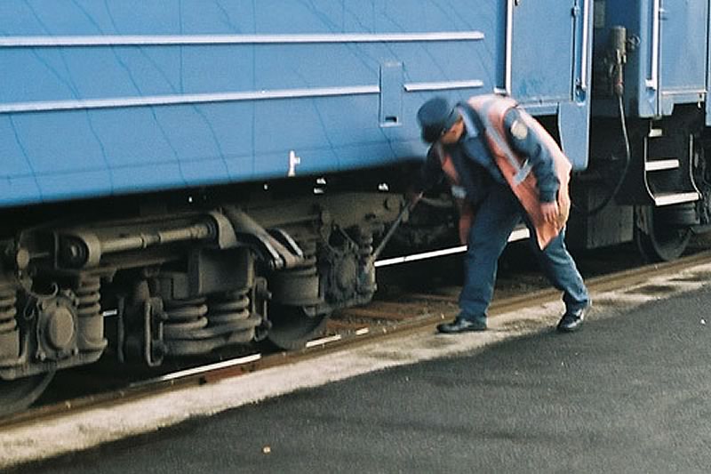 Trabajador del transiberiano verificando los bogies